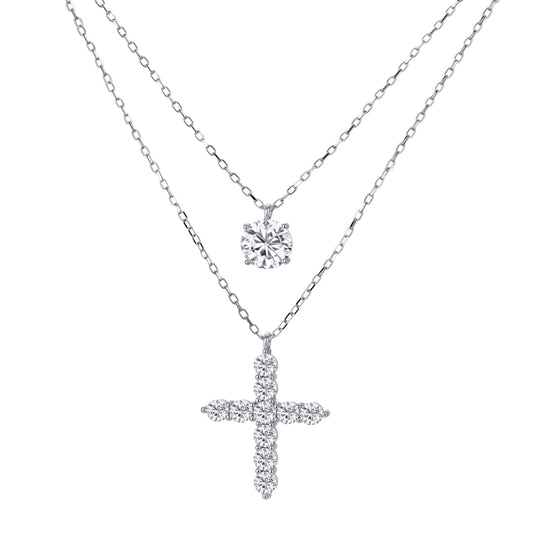 Two delicate sterling silver necklaces with moissanite stones - one solitaire pendant and one cross pendant on white background.