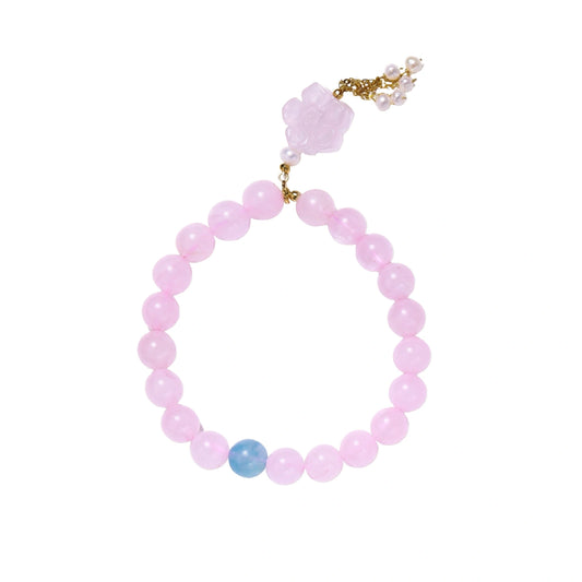 Stretchy beaded bracelet with pink rose quartz, blue aquamarine, carved floral pendant, and pearl tassel clasp.