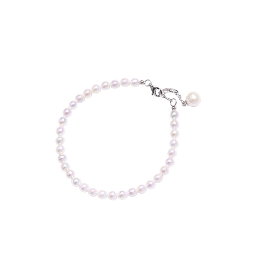 Adjustable bracelet featuring lustrous freshwater pearls with rhodium-plated sterling silver clasp on cream background.