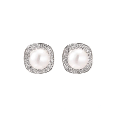 Rhodium-plated sterling silver stud earrings with round freshwater pearls surrounded by geometric crystal halos on cream background.