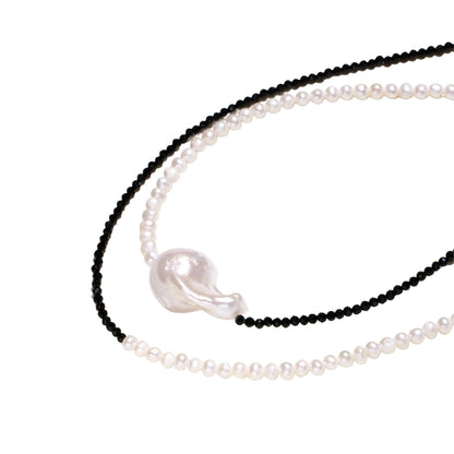 Double-strand necklace with black faceted quartz and white pearls featuring an oversized baroque pearl centerpiece