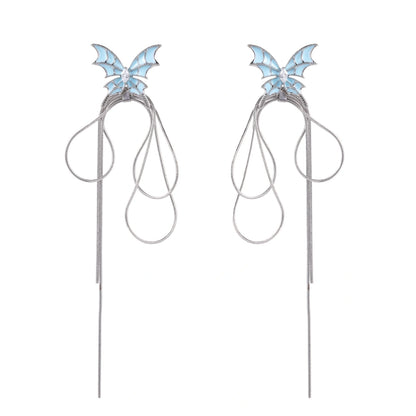 Long silver-tone earrings with powder blue enamel butterfly studs and flowing chain tassels on cream background