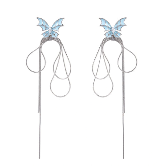 Long silver-tone earrings with powder blue enamel butterfly studs and flowing chain tassels on cream background
