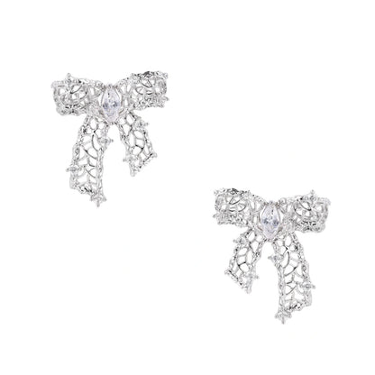 Filigree bow-shaped earrings with marquise center stone and lattice ribbon tails in gold and silver finishes
