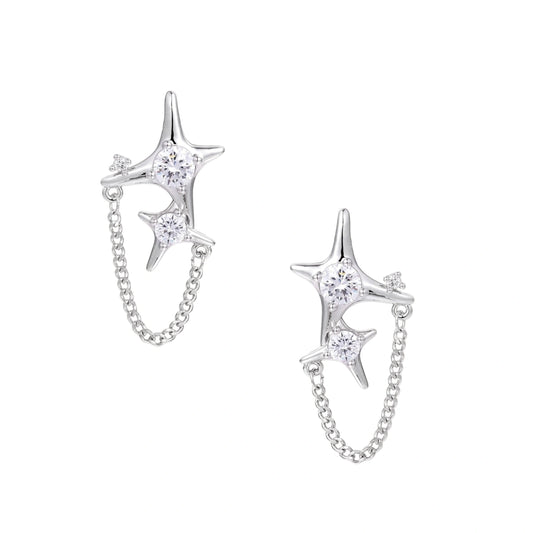 Silver star studs with crescent moon cutouts and zirconia stones connected by delicate chains on white background