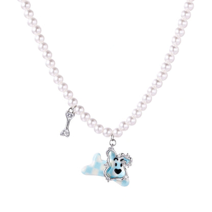 Pearl necklace with playful blue dog pendant accented with sparkly crystals on cream background.