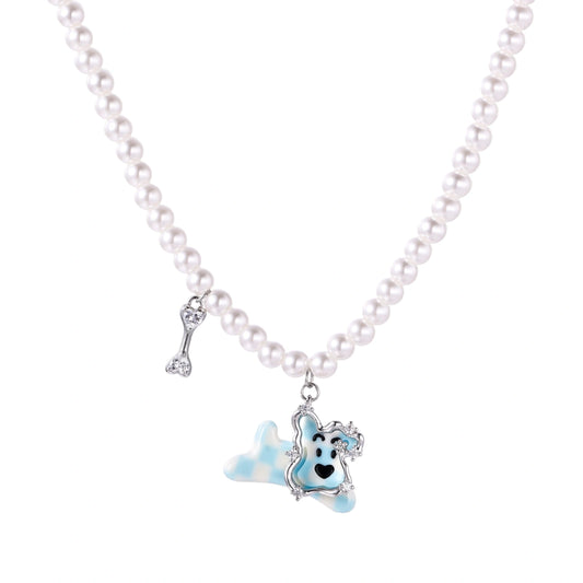 Pearl necklace with playful blue dog pendant accented with sparkly crystals on cream background.