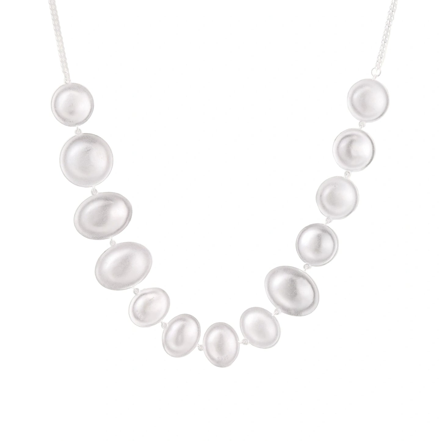 Graduated pearl-finish silver discs forming an organic bubble bib necklace on delicate chain against cream background.