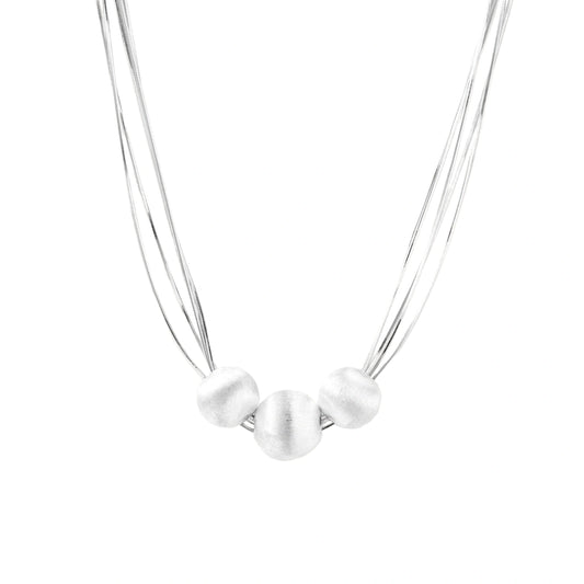 Sterling silver multi-strand necklace with three brushed round beads on cream background