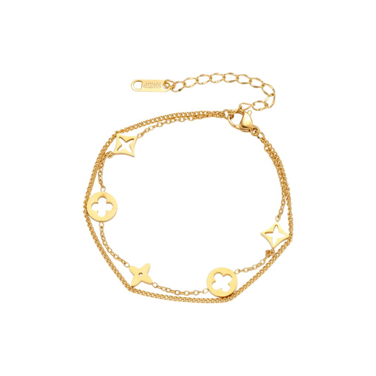 Double-layer gold-plated bracelet with quatrefoil and star charms on cream background, 18K gold finish.