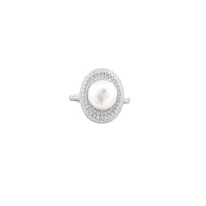 Silver ring with lustrous white pearl center surrounded by sparkling crystal halo on light background.