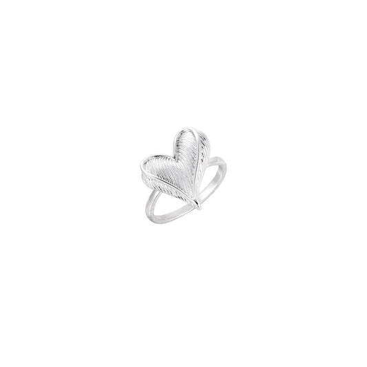 Silver ring with 3D heart formed by textured feather-like elements, white gold plated eco-brass on neutral background.